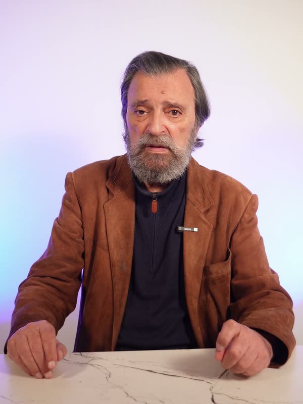 Un hombre mayor, sentado a una mesa, cuenta a cámara cómo funciona OkayDay.